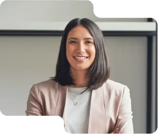 Confident female professional with a welcoming smile, dressed in a chic pink blazer and white top, representing the skilled and friendly team behind our cryptocurrency exchange services.